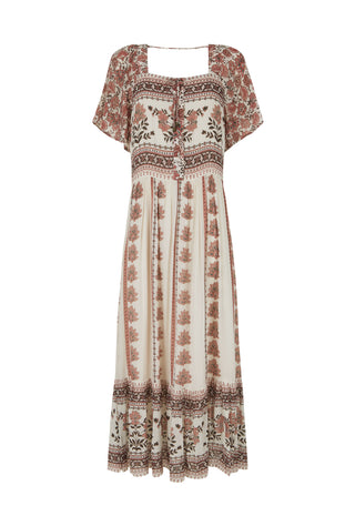 A woman modeling a bohemian-style maxi dress with a brown and beige floral pattern